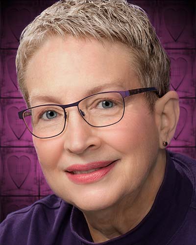 A woman with short blonde hair wearing glasses.