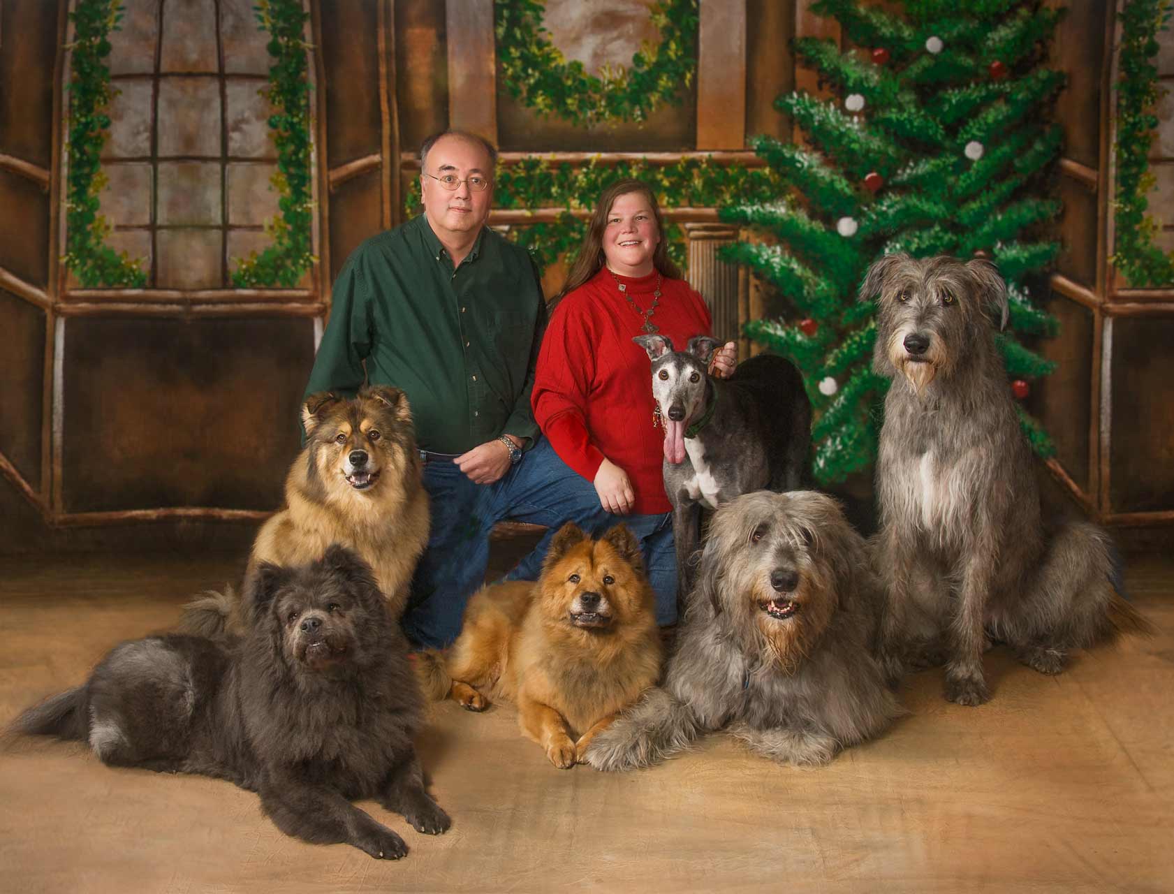 A man and woman posing with their dogs.