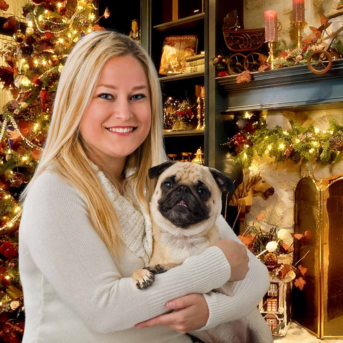 A woman holding her dog in front of a christmas tree.