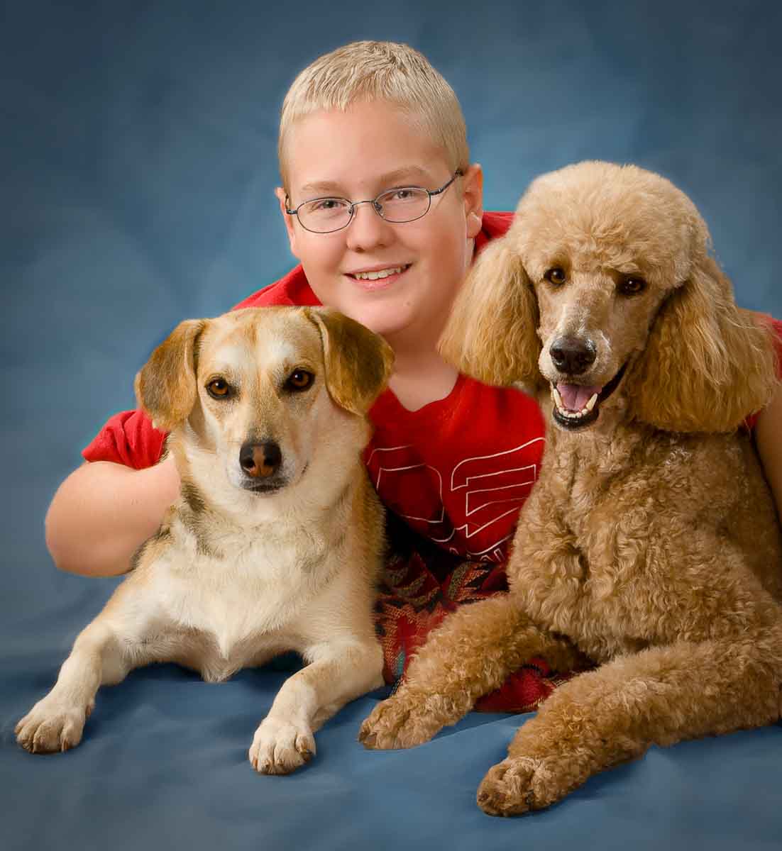 A boy and two dogs pose for the camera.