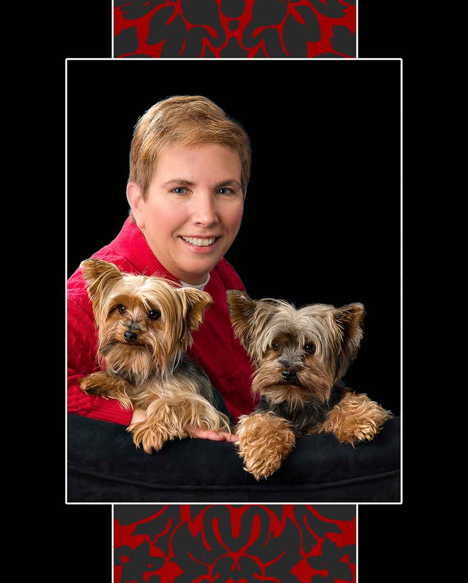 A woman and two small dogs sitting on top of a chair.